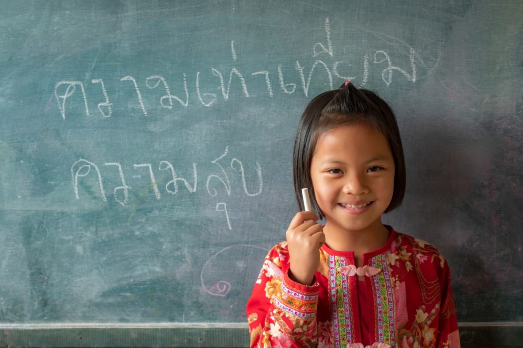 A girl writes on a blackboard at a school in Chiang Mai Thailand