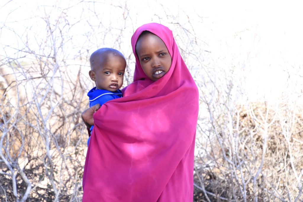 A girls carries her baby brother in an IDP camp in Somaliland