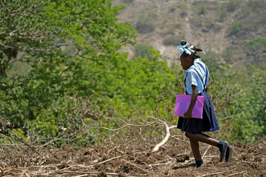 Chedeline, 12, and her sister cross failed crop field to get to school