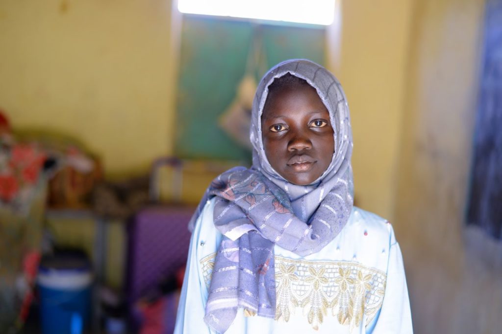 Muna is a 13-year-old girl looking at the camera