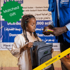 A girl in Sudan receives school supplies from Plan