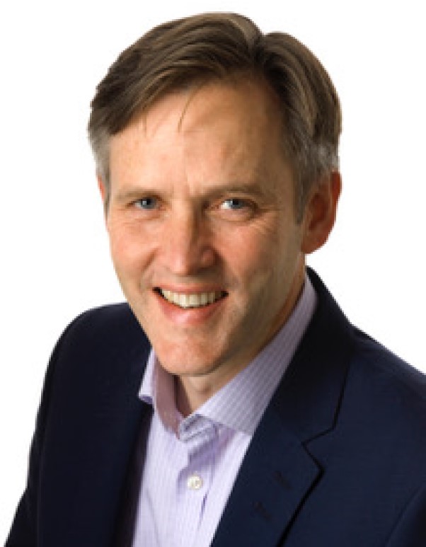 Smiling man in a suit and light shirt, close-up portrait on a white background.